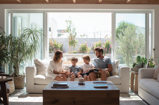 A household planning board with a family discussing daily routines and age-based wellness priorities in a calm modern home
